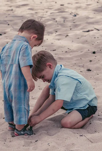 Niño Ayudando Hermano Ponerse Los Zapatos Una Playa Arena —  Fotos de Stock