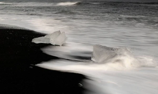 アイスランドの氷の結晶とダイヤモンドビーチの海岸に飛び散る水のクローズアップショット — ストック写真