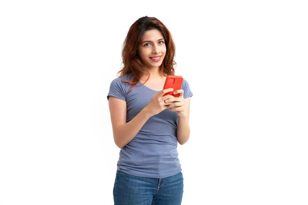 白い背景に赤い携帯電話を持っている笑顔の幸せな女性のスタジオショット — ストック写真