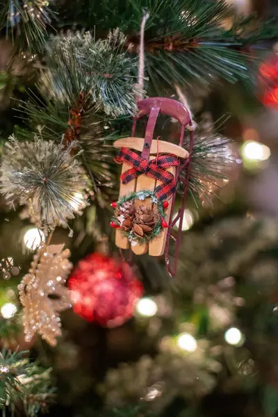 挂在圣诞树上的一个小小的圣诞装饰品的垂直照片 — 图库照片