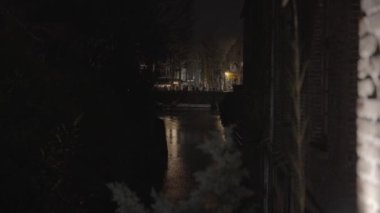 Kortrijk, Belçika 'da yağmurlu bir akşamda, bir sokak yolu üzerindeki binanın yanından geçen bir manzara.