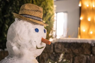 Kış günü havuç burunlu, şapkalı ve düğmeli bir kardan adam.