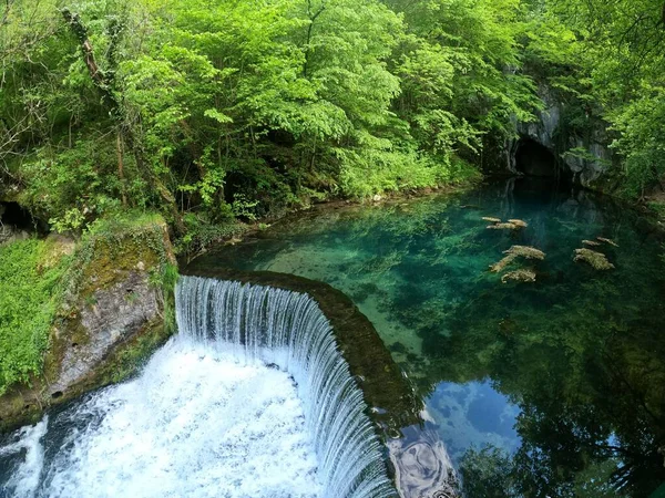 Una Vista Impresionante Estanque Cristalino Color Turquesa Una Cascada Rodeada —  Fotos de Stock