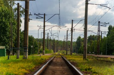 Güneşli bir günde, elektrik direkleriyle dolu bir istasyonda güzel bir demiryolu manzarası.