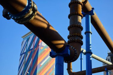 Renkli bir binanın arka planına ve mavi gökyüzüne yakın bir boru..