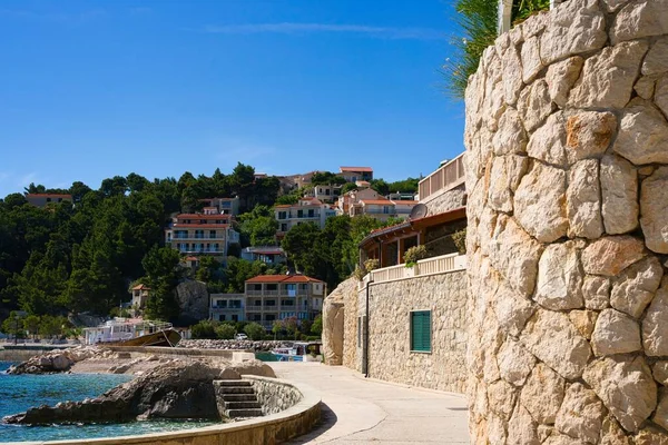 克罗地亚Brela的海滩上 楼梯很小 四周是一堵巨大的石头墙和躲在树上的橙色房屋 — 图库照片