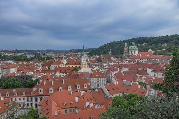 Kasvetli Gökyüzünün Altında Yeşil Ağaçlarla Çevrili Kırmızı Çatılı Prag Şehrinin — Stok fotoğraf