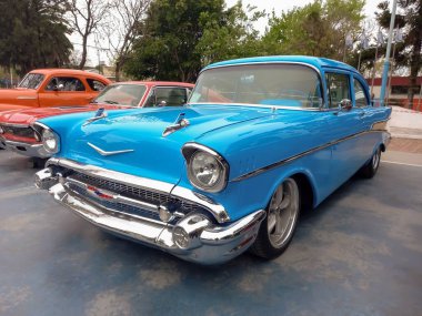 Lanus, Arjantin - 25 Eylül 2022: Eski gökyüzü mavi 1957 Chevrolet Bel Air spor sedan bir parkta iki kapı. Simgesel klasik araba.