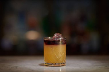 Lezzetli bir New York viskisi, ekşi alkollü bir içecek ve masada buz küpü.