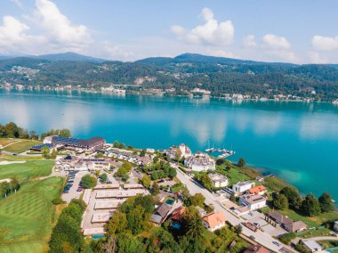 Avusturya 'daki Worthersee Gölü' nün binalarıyla güneşli sahil manzarası.