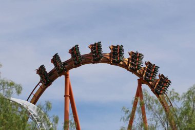 A view of the roller coaster sharp bank turn suspended in Six Flags Magic Mountain clipart