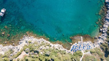 Mavi okyanusta yüzen bir teknenin havadan görüntüsü.