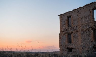 Gün batımına karşı terk edilmiş eski bir tuğla bina.