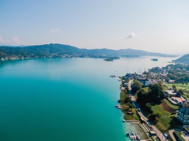 Avusturya 'daki Worthersee Gölü' nün binalarıyla güneşli sahil manzarası.