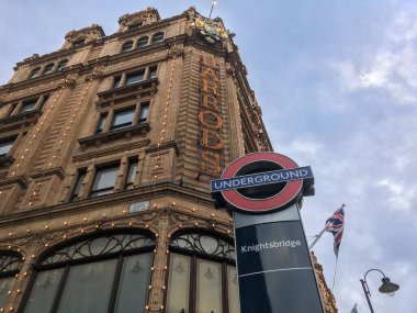 Londra caddesinin yanındaki metro sembolünün alçak açılı görüntüsü, İngiltere