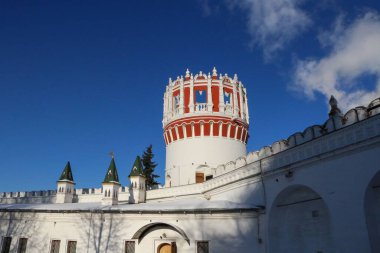 Moskova, Rusya 'daki kırmızı ve beyaz Novodevichy Manastırı mavi bulutlu gökyüzü arka planı üzerine