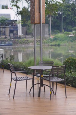 Gölün kenarındaki tahta platformda demir sandalye.