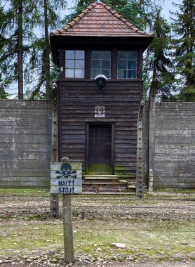 Auschwitz toplama kampındaki güvenlik kulesinin önündeki ahşap tehlike işareti.