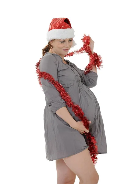 Uma Jovem Grávida Usando Chapéu Papai Noel Ouropel Tocando Sua — Fotografia de Stock