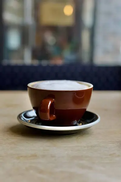 Egy Habos Bögre Cappuccino Asztalon Egy Kávézóban Homályos Háttérrel — Stock Fotó