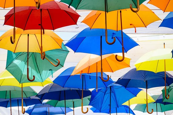 町の通りを飾るカラフルな傘をぶら下げている多くの背景 — ストック写真