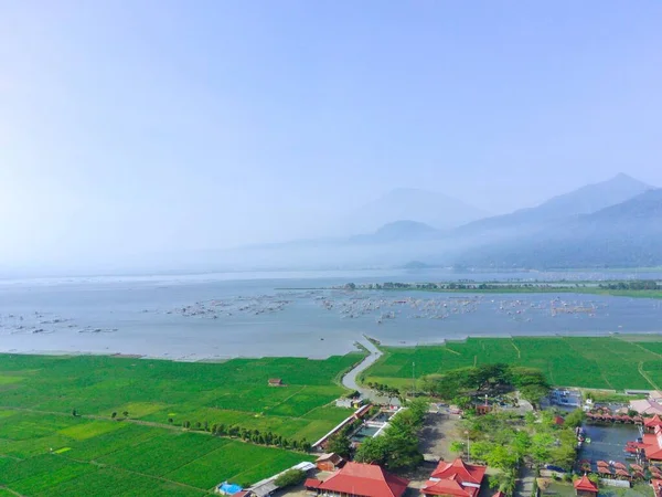 Ein Drohnenblick Auf Reisfelder Neben Rotgedeckten Gebäuden Mit See Und — Stockfoto