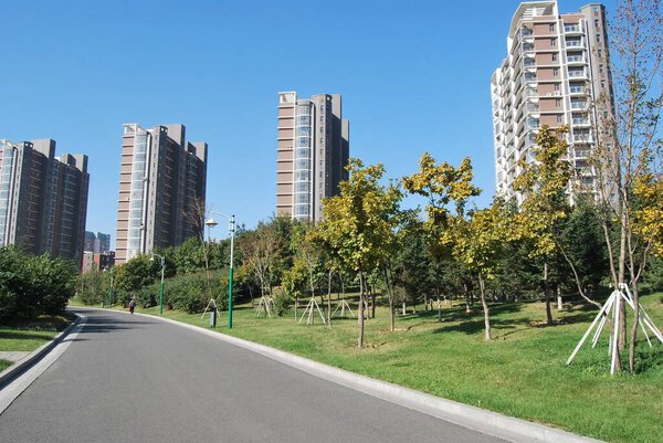 A paved road with tall apartment buildings in a residential setting