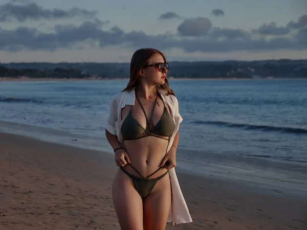 一个身穿泳衣的漂亮的白人女人站在沙滩上 背景是蓝色的大海 — 图库照片