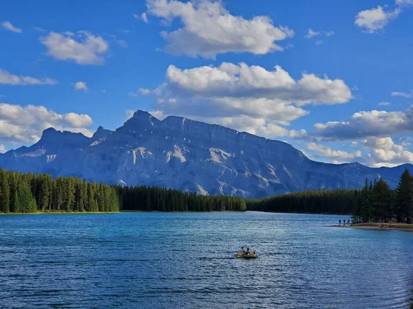 加拿大艾伯塔省 一艘背景为乌云蓝天的小船 在艾伯塔省落基山脉的一个湖中 — 图库照片