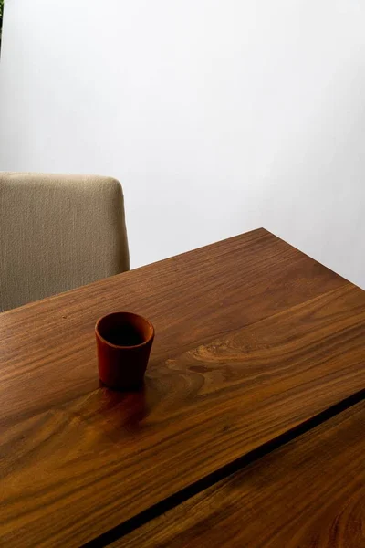 居心地の良い椅子で木製のダイニングテーブルのスタイリッシュな赤いカップの垂直方向の高い角度ビュー — ストック写真