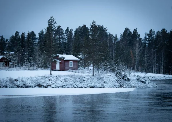 Mała Czerwona Chatka Otoczona Lasem Jeziorem Zimie — Zdjęcie stockowe