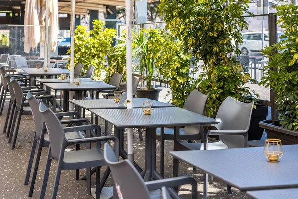 奥に鉢植えのある晴れた日には 灰色の椅子とテーブルが並ぶ屋外カフェ — ストック写真