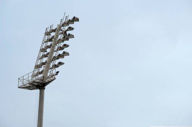 Mavi gökyüzündeki yüksek stadyum ışıklarının alçak açılı çekimi