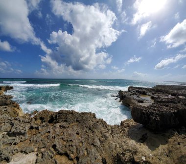 Güneşli bir günde dalgalı bir deniz kıyısı