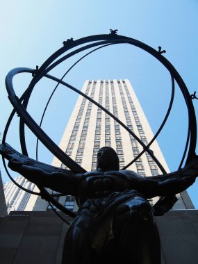 Bir heykelin alçak açılı çekimi ve Manhattan, New York 'taki Rockafella Center.