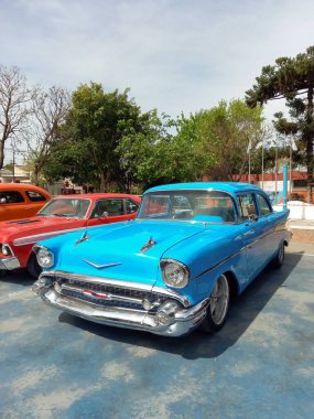 Lanus, Arjantin - 25 Eylül 2022: Eski gökyüzü mavi 1957 Chevrolet Bel Air spor sedan bir parkta iki kapı. Simgesel klasik araba.