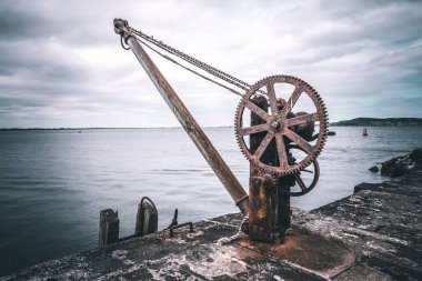 Bulutlu bir gökyüzüne karşı antik bir vincin yakın çekimi.