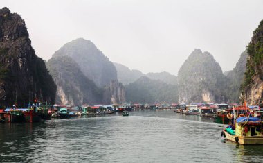 Vietnam 'da sisli bir günde Halong Körfezi' nin kayalıklarında bulunan liman manzarası.