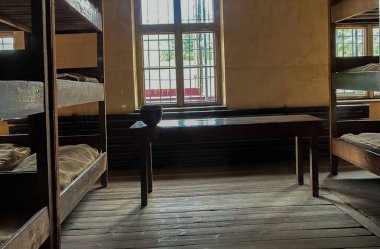 Polonya 'daki Auschwitz toplama kampında yataklar ve küçük tahta bir masa.