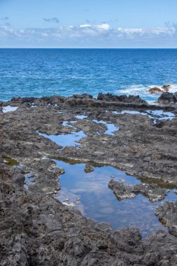 Huzurlu bir gökyüzü arka planına sahip bir kıyı şeridinin dikey görüntüsü