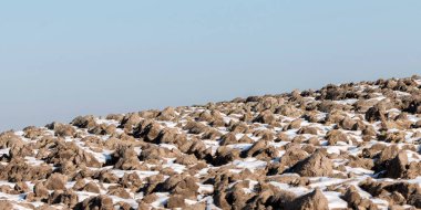 Kışın karla kaplı kayalık bölgenin üzerindeki mavi gökyüzü