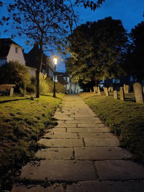 Akşamları yeşil parktaki kaldırım kaldırımının dikey görüntüsü.