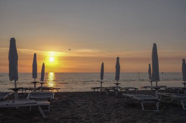 Gün batımında kumlu deniz manzarası.