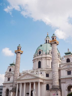 Avusturya, Viyana 'da parlak bir gökyüzünün altındaki tarihi Karlskirche kilisesinin dikey alçak açılı görüntüsü.