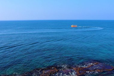 İsrail, Acre Limanı 'nın mavi sularında yelken açan kırmızı bir tekne.