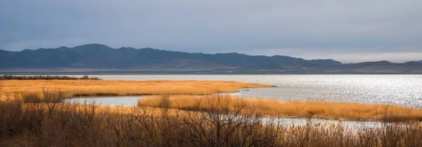 stock image Utah Lake During Fall Day with Sun Shining Through the Clouds on Grass.