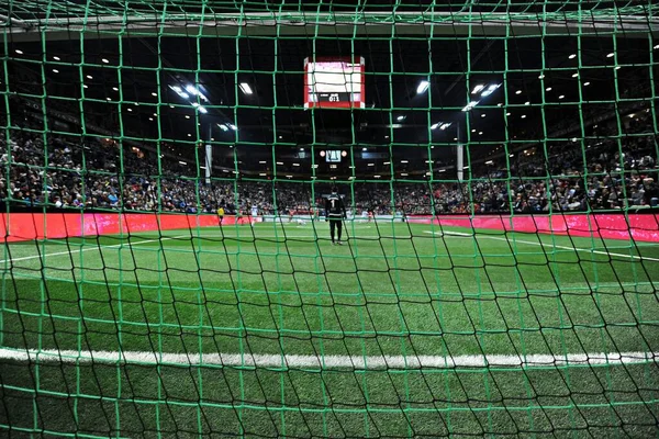 サッカーネットで見られるスタジアムで試合を観戦する観客の群衆 — ストック写真