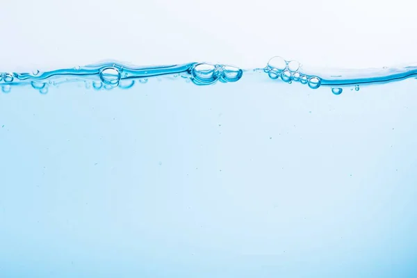 白い背景に青い水といくつかの泡のクローズアップショット — ストック写真