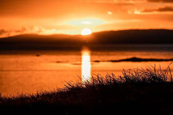Eine Schöne Aufnahme Eines Leuchtend Orangen Sonnenuntergangs Über Dem Wasser — Stockfoto