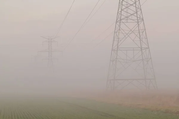 Una Hermosa Toma Líneas Torres Transmisión Que Desvanecen Niebla —  Fotos de Stock